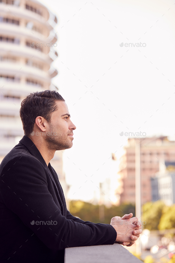 Profile Shot Of Businessman Standing Outside Office Building With City Skyline In Background