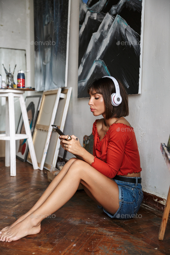 Beautiful young woman artist sitting in the art studio