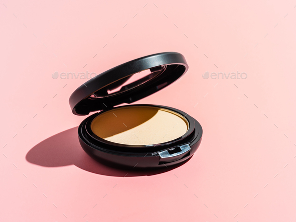 Compact powder on pink background, copy space