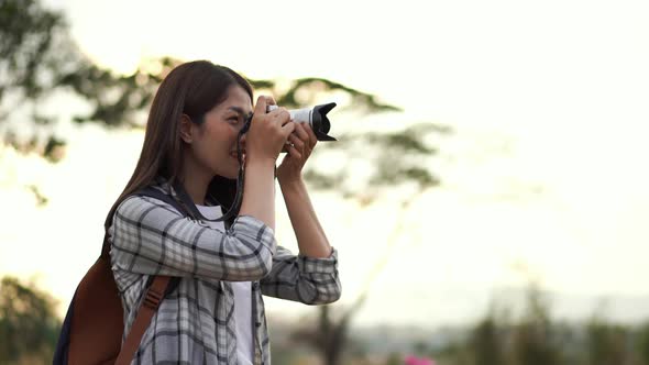 tourist woman taking a photo with her camera in nature alt