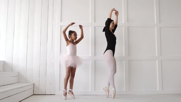 Woman Teaching African Girl How to Dance Ballet alt