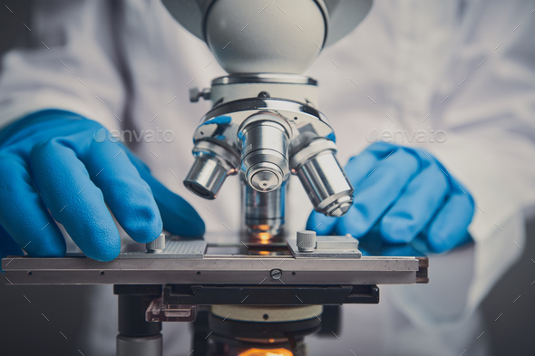 Close up of examining of test sample under the microscope - Stock Photo - Images