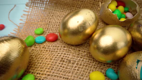 Easter Eggs Painted in Gold Color on Blue Wooden Table Close Up