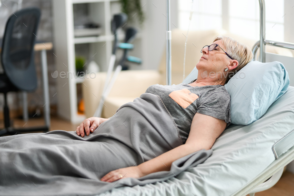 Elderly age woman sleeping in a nursing home bed