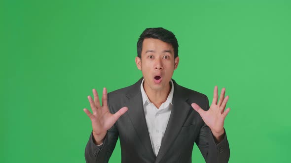 The Shocked Asian Business Man Grabbing Her Head While Saying Wow On Green Screen Background alt