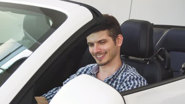 Handsome Happy Young Male Driver Holding Car Keys Sitting in His Auto alt