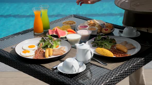 Asian Woman Waitress with Tray Put Breakfast Food in Restaurant at Luxury Hotel alt