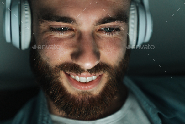 Close up of a smiling bearded man wearing earphones