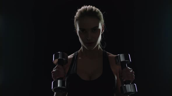 Smiling Woman Exercising Dumbbells in Gym. Fit Girl Smiling During Sport Workout alt