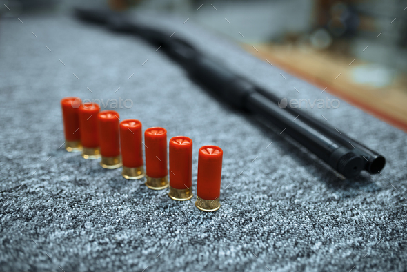 Rifle and row of ammo in gun shop, closeup, nobody