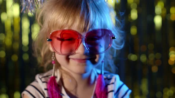 Portrait of Trendy Stylish Girl Looking at Camera Smiling Child Kid in Neon Light at Disco Club alt