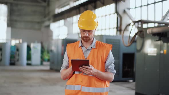 Man engineer in uniform calculating on tablet alt