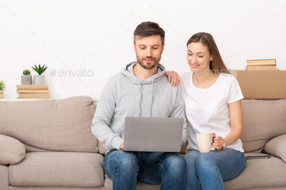 Happy young couple buying furniture into new apartment