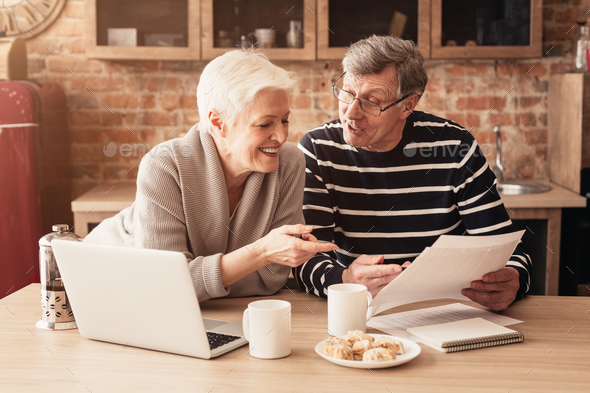 Happy Senior Couple Planning Family Budget Together With Laptop And Papers - Stock Photo - Images