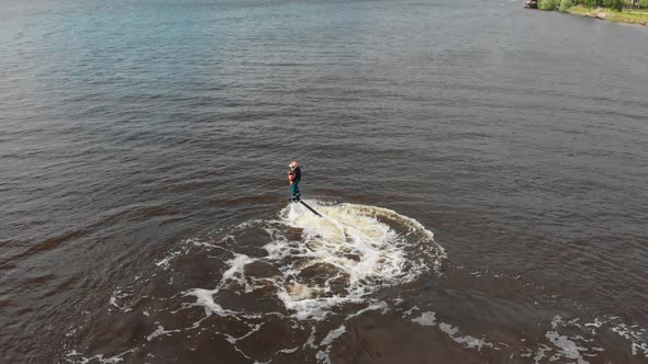 Water Sports  a Man with a Little Kid Flying on the Flyboard  Aerial View alt