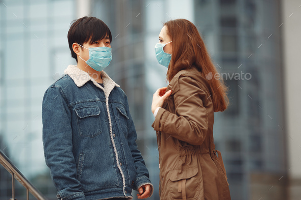 A woman and Chinese man are wearing protective masks