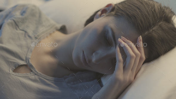 Young woman lying in a hospital bed at night