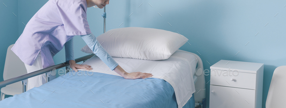 Expert young nurse making the bed at the hospital
