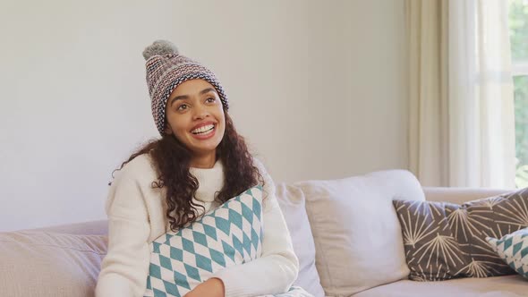 Happy woman in warm clothing sitting on sofa watching television 4K 4k alt
