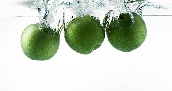 Granny Smith Apples, malus domestica, Fruits entering Water against White Background, Slow Motion 4K alt