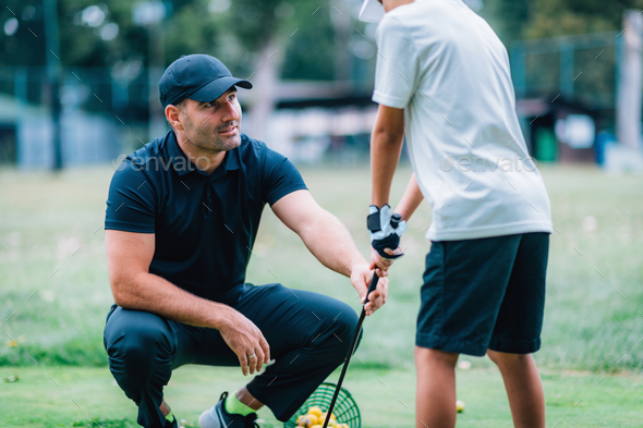 Personal Golf Lesson for Children. Instructor Teaching Young Boy How to Play Golf.