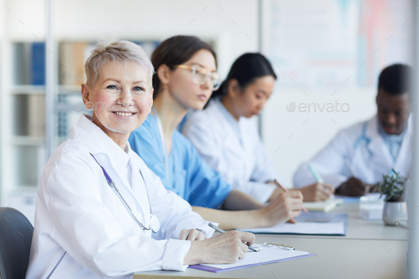 Mature Female Doctor Smiling in Meeting