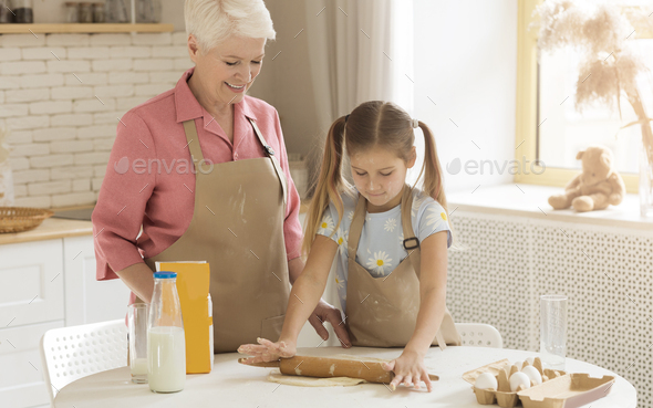 Adorable Child Learning How To Bake From Her Granny At Home Stock Photo 