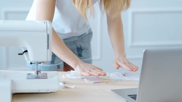 Concept During Self-isolation and Quarantine. Woman Sews a Mask alt