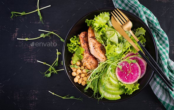 Buddha bowl dish with chicken fillet, chickpea, cucumber, radish, fresh lettuce salad, pea sprouts - Stock Photo - Images