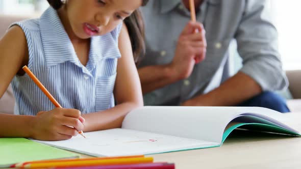 Father helping daughter with her school project alt