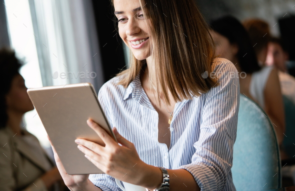 Young female entrepreneur reading electronic book on digital tablet in modern restaurant