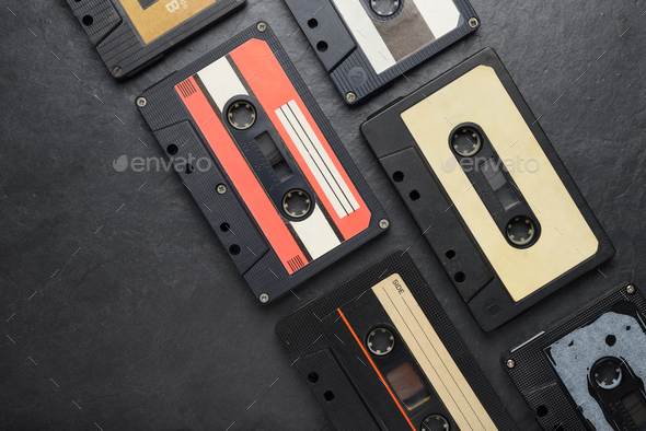 Black audio tape compact cassettes on black background