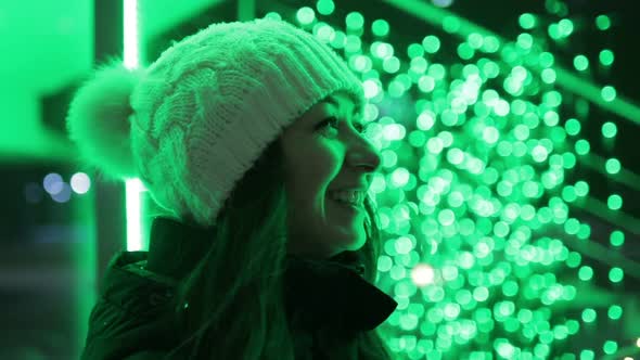 Attractive Girl Laughs on the Bokeh Background of Garlands