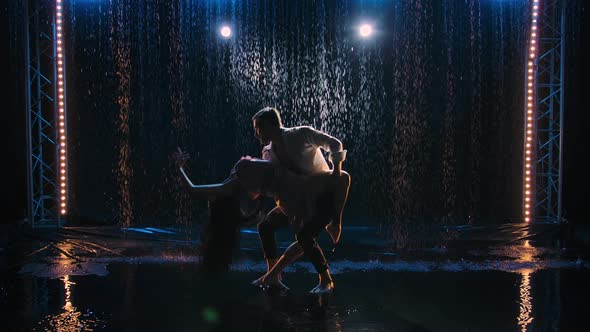 Silhouettes of Tender Loving Couple Whirl in Dance Closely Touching Their Bodies and Holding Hands alt