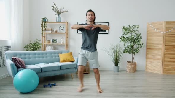 Portrait of Young Man Doing Sports Exercises and Talking Showing Thumbsup Gesture Looking at Camera alt