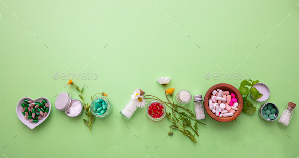 Homeopathy, globules and medicibe on green background Stock Photo by rawf8