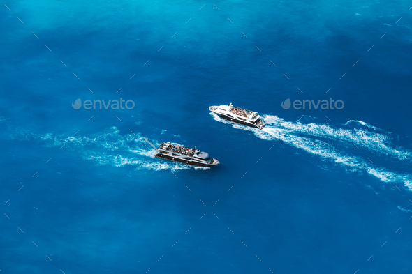 Fully occupied tourist boats in open sea on trip to the world most famous Navagio Beach on Zakynthos - Stock Photo - Images