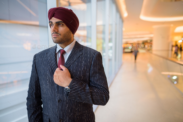 Portrait of Indian businessman with turban looking through window