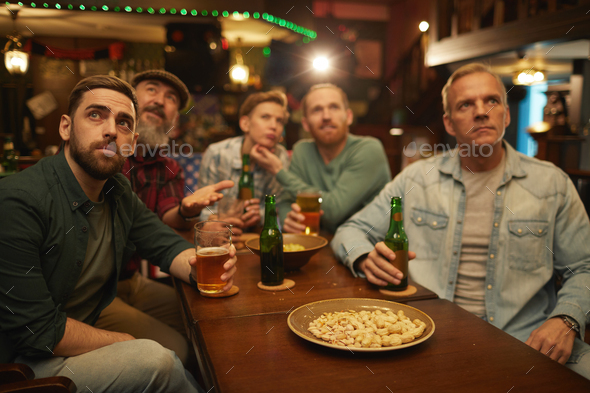 Group of friends drinking beer in sport bar