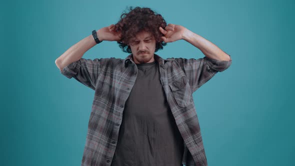 Young Hipster Irritated By the Sound Too Loud with His Fingers in His Ears Screaming and Shouting to alt