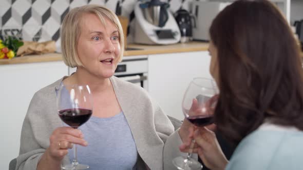 Video of two generation women drinking wine at home. Shot with RED helium camera in 8K. alt