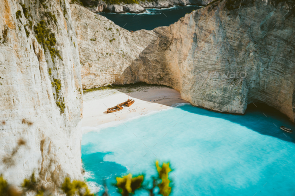 Famous shipwreck of Navagio beach with turquoise blue sea water surrounded by huge white limestone - Stock Photo - Images