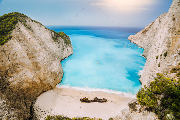 Shipwreck on Navagio beach. Azure turquoise sea water and paradise sandy beach in evening light - Stock Photo - Images