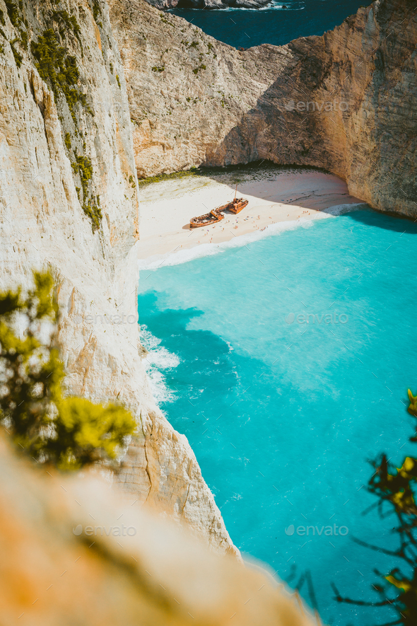 Vertical shot of shipwreck on Navagio beach with turquoise blue sea water surrounded by huge white - Stock Photo - Images