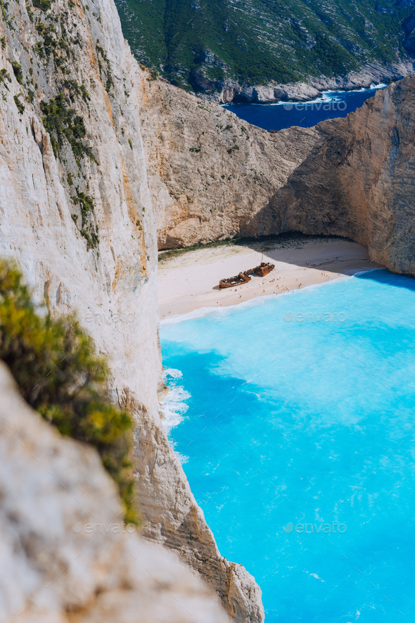 Limestone chalk colored like huge cliff rocks surrounding Navagio beach with Shipwreck and azure - Stock Photo - Images