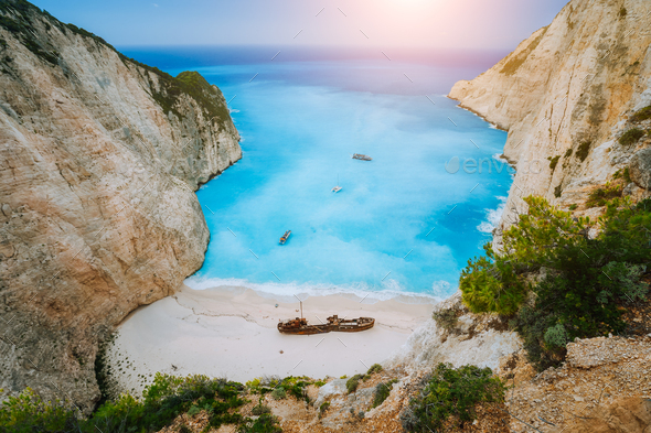 Breathtaking view of Shipwreck middle of sandy Navagio beach surrounded by azure deep turquoise sea - Stock Photo - Images
