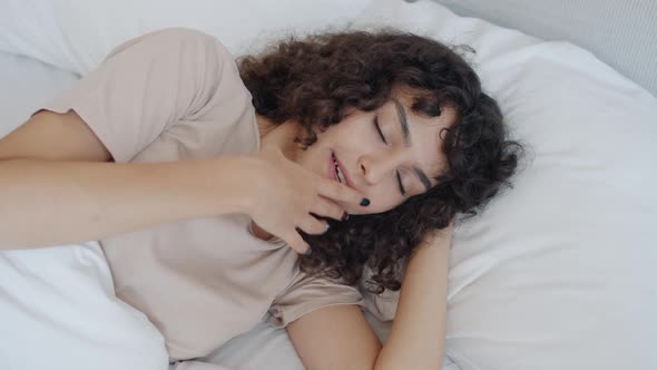 Beautiful Young Lady Lying in Bed Yawning Then Sleeping Indoors at Home alt