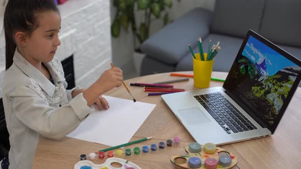Young Girl Spending a Time Drawing Using Online Lessons on Laptop Distance Learning Online Education alt