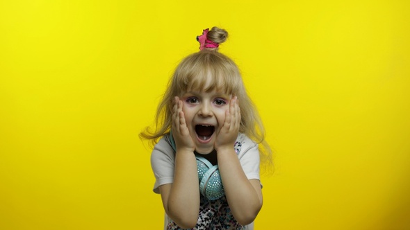 Child Show Amazement, Fooling Around, Smiling, Looking Surprised Shocked on Yellow Background alt
