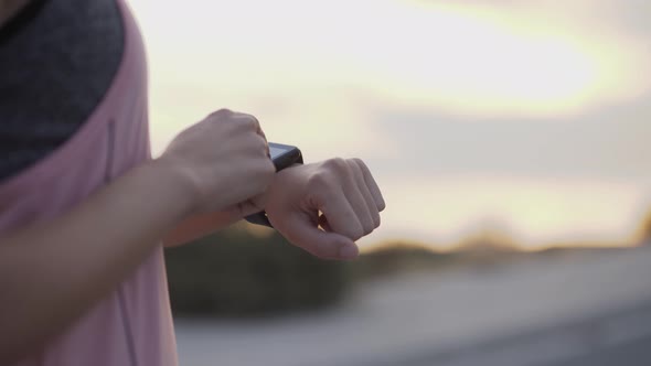 Woman Checking Heart Rate on Smartwatch After Exercising Outdoors